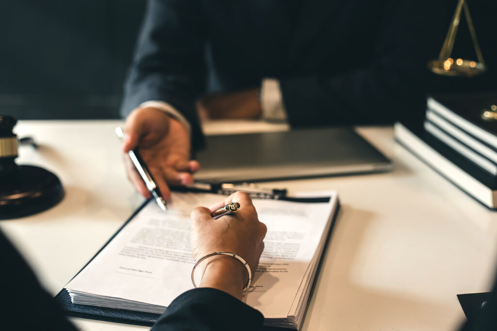 Two people discussing a document with a pen.