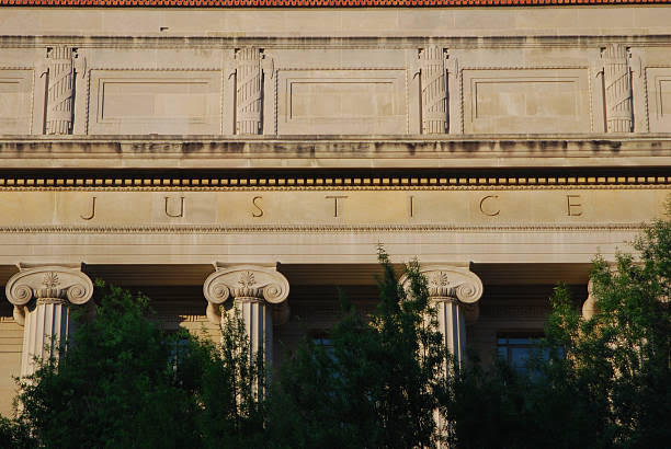 Justice building facade with columns and trees.
